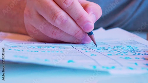 Cinematic macro of a hand filling a survey or job application form. Defocused background, soft window light. Visualizes questionnaire, voting, human resources hiring process and research.