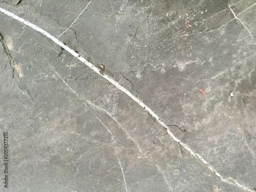 Dark grunge concrete floor texture with crack. Minimalist stone background