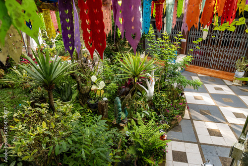 Fotografía Colorful prayer flags adorn a lush garden in Wat Phra That Doi Suthep, Chiang Mai, Thailand, creating a vibrant and serene atmosphere