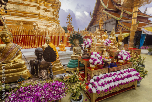 Canvastavla Golden Buddha statues and offerings of flowers at Wat Phra That Doi Suthep, a sacred temple in Chiang Mai, Thailand