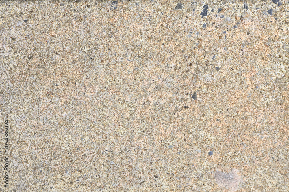 Fototapeta premium Rough beige concrete texture background with small dark speckles, creating a natural, rugged look