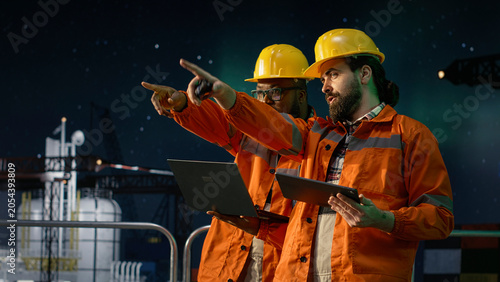 Photos Analyzing oil crisis logistics, laptop and drilling barge engineering team men under green aurora borealis, Working together, maritime blockade strategy and offshore rig colleagues, camera A