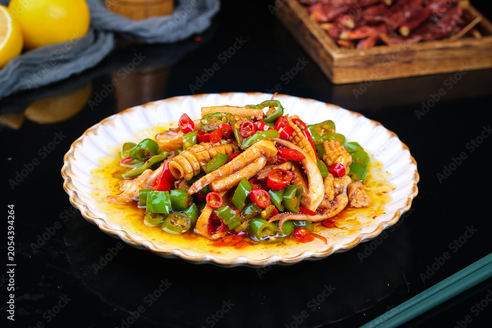 Fototapeta premium Chinese Stir-Fried Squid with Peppers - Traditional Spicy Seafood Dish on Decorative Plate