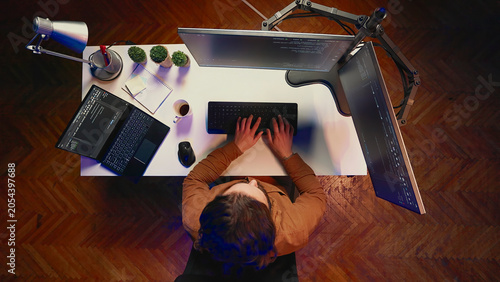 Photos Top-down view of remote worker typing code in personal office, using JavaScript language to develop software application