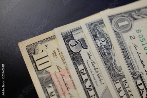 Dollar banknotes from 1 to 10 dollars, close-up top view. US dollar banknotes in 1, 2, 5 and 10 dollar denominations, top view
