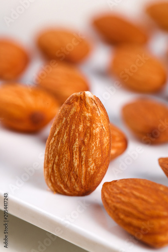 Fotografia Roasted Almonds Close-Up on White Plate