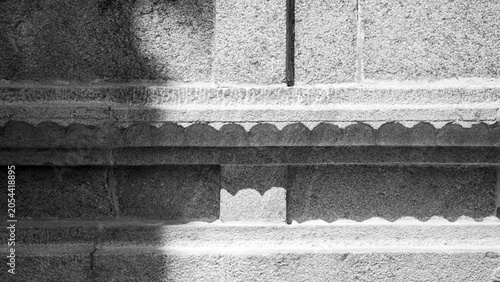 Photography Stone temple wall with carved scalloped border detail in black and white photogr