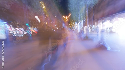 Abstract light blurring as person walks down city street at night.