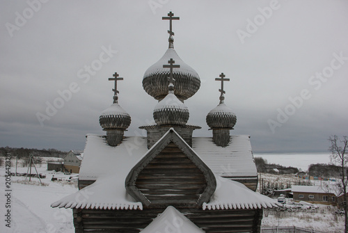 Obraz na plátne Traditional ancient Russian wooden church with onion domes in winter landscape