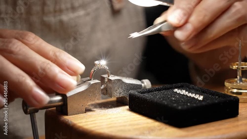 Artisan carefully setting diamond on ring in workshop environment with jewelry tools and gemstones for fine craftsmanship