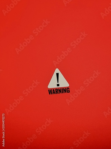 A white triangular sign features a black exclamation point and the word 