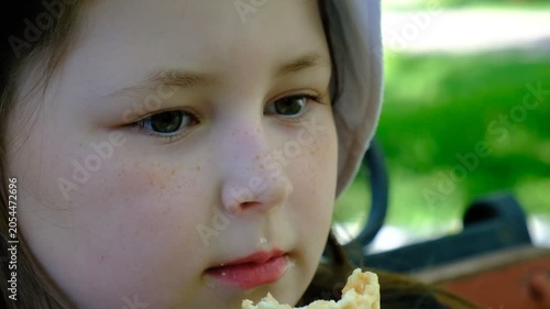 A cheerful portrait of a young girl enjoying ice cream in a waffle cone on a hot summer day. Mood is carefree, playful, summery. Childhood, sunshine, and the sweet taste of summer.