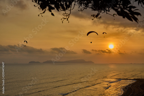 Photography Chasing the last light — paragliders drift in silent communion across a burnishe