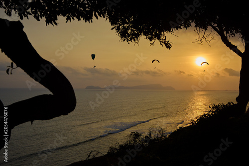 Valokuva Chasing the last light — paragliders drift in silent communion across a burnishe