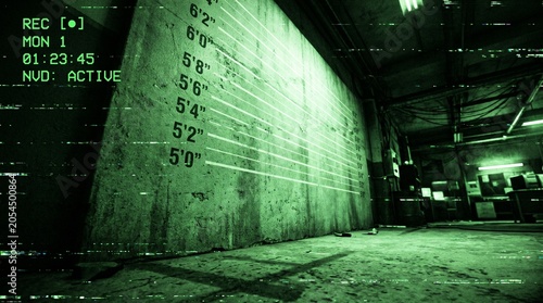 CCTV night vision surveillance footage of empty police lineup mugshot wall with height chart in gritty warehouse
