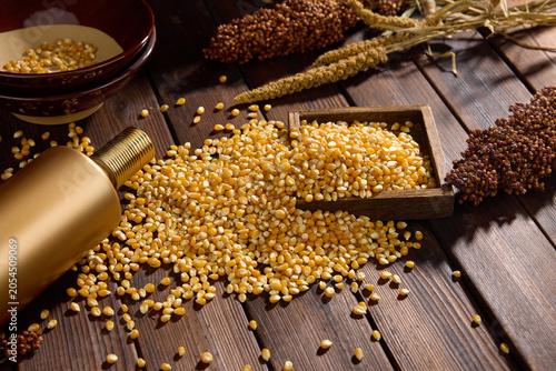 Photography Dried corn kernels with wooden scoop on rustic wooden table