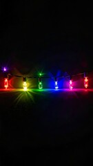 A colorful string of fairy lights against a dark background