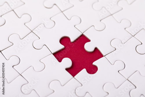 Photography White jigsaw puzzle with red missing piece gap close up