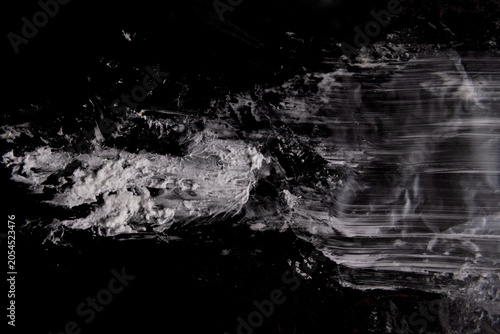 Grunge white brush stroke and smudge texture on isolated black background