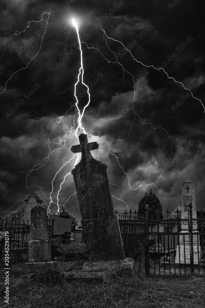 Obraz premium Old creepy graveyard on stormy winter day in black and white