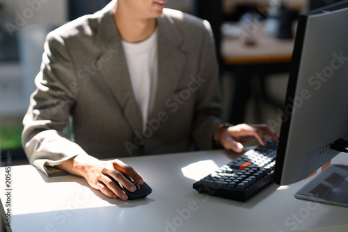 Closeup businessman working at desktop Computer with Keyboard and Mouse in Modern Office