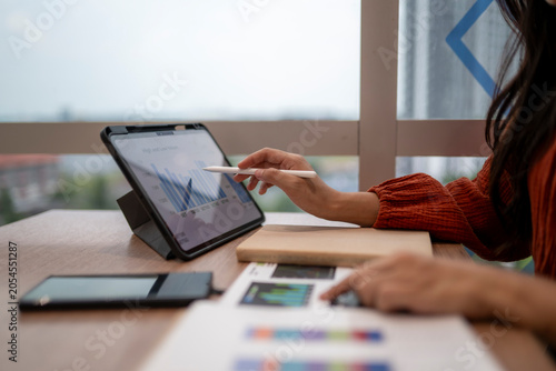 Woman working on financial data analysis using tablet
