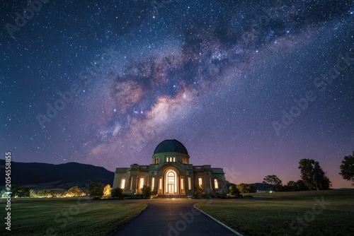 Grand domed building bathed in light beneath a vibrant starry sky