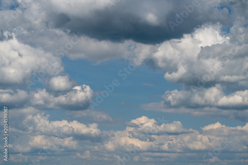 Bild auf Leinwand Expansive sky filled with scattered cumulus clouds over distant horizon