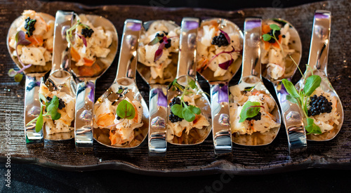 Canapes on spoons with seafood and caviar