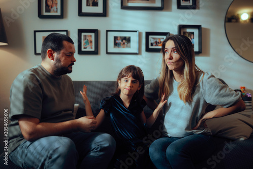 Obraz na płótnie Unhappy Little Girl Separating Arguing Parents from Fighting