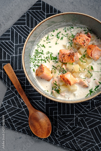 Creamy Finnish lohikeitto soup featuring seared salmon pieces, potatoes in rich broth and dill topping. Authentic Scandinavian salmon chowder, wholesome restaurant-style seafood dish, top view