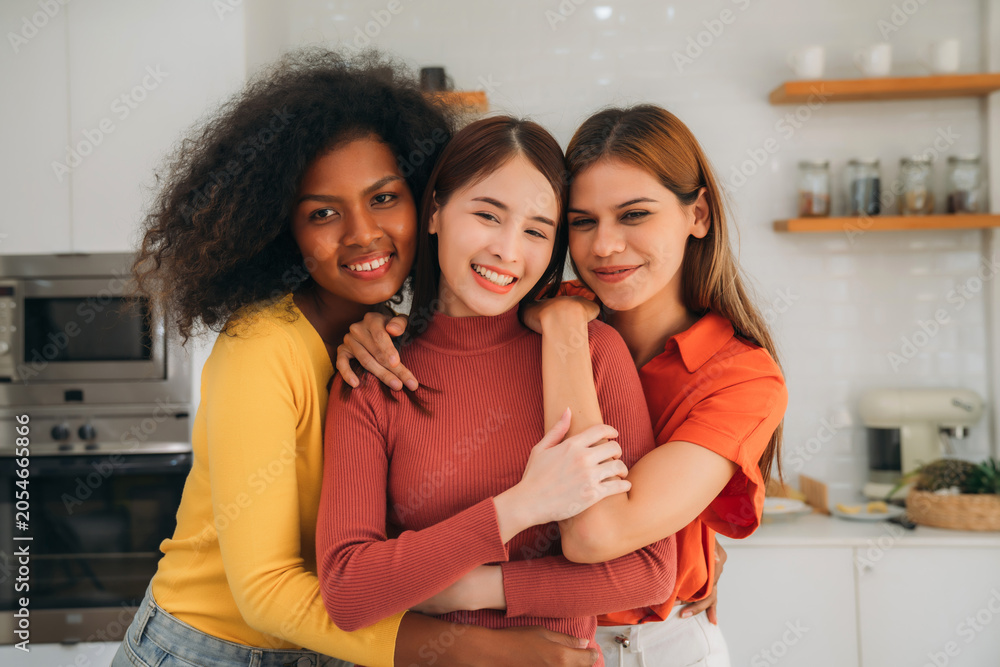Obraz premium Happy Smiling Diverse Young Women Friends Hugging Together While Enjoying Cooking Healthy Food in Bright Modern Home Kitchen.