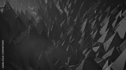A monochrome abstract background featuring many sharp geometric pyramids