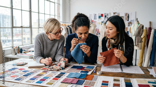 Fabric buyer textile swatch designer color studio sample fashion woman, Retail buyer examining fabric swatch bright studio, focused woman comparing textile color sample for fashion design
