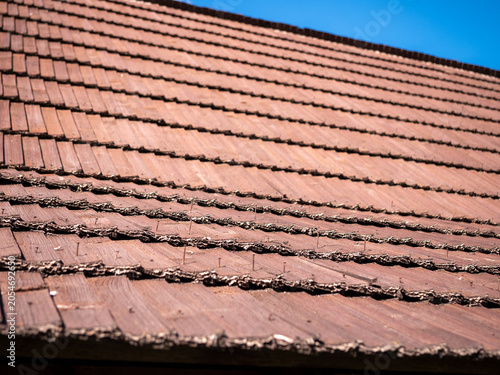 Quadro em tela Aged wooden shingle roof with exposed and loosening nails, close-up of weathered roofing material highlighting maintenance, repair and building inspection needs