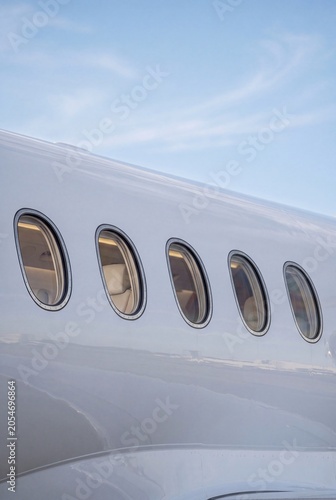 Private jet fuselage windows close up luxury aircraft exterior detail