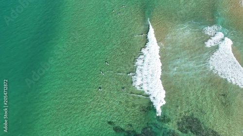 Drone video aerial view of surfers waiting to catch the next wave at a beach in Sydney Australia in summer 