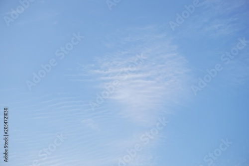 Bild auf Leinwand Clear blue sky with gentle soft white clouds in bright sunny summer day backdrop