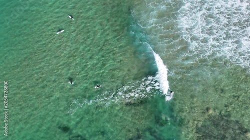 Drone video aerial view of surfers waiting to catch the next wave at a beach in Sydney Australia in summer 