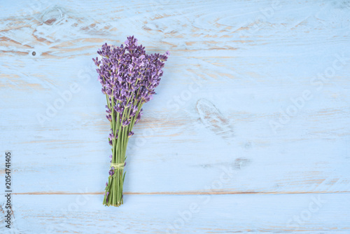 Top view of a fragrant lavender bouquet on a pastel blue wooden board. Rustic floral flat lay with natural purple flowers, copy space and soft vintage style.