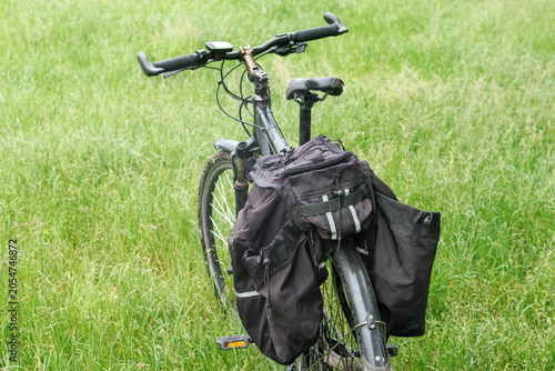 Fotografie Touring Bicycle with Pannier Bags on Meadow