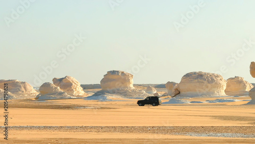 Photos 4x4 jeep driving fast across sandy desert plain among rock formations