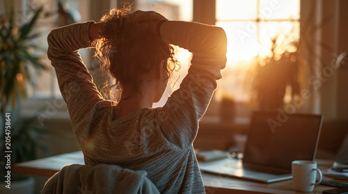 Faceless Remote Worker Stretching Arms at Laptop in Warm Sunset Home Office, Ergonomic Wellness Break and Relaxation Concept