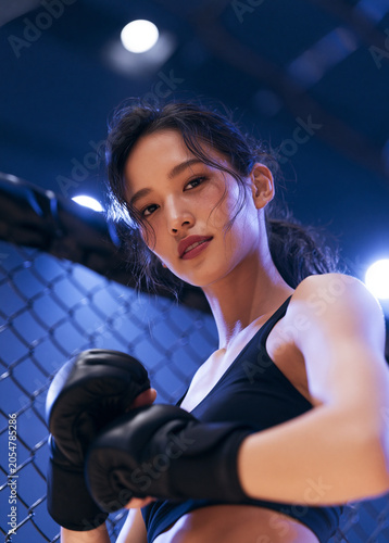 Woman Boxer Posing with Gloves in Cage