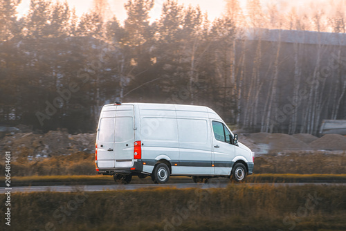 Commercial delivery van driving near forest