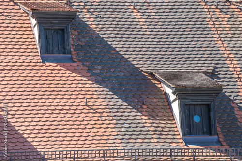 Foto Dachgauben mit prägnanten runden  Löchern in Fensterladen am Ziegeldach mit Biberschwanzziegeln an der Klosteranlage St