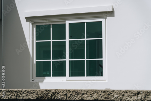 White sliding window glass window window frame modern window exterior wall sunlight shadow home exterior residential building architectural detail clean design