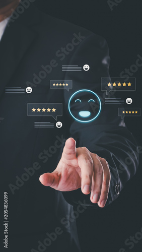 A businessman touches a virtual interface displaying a glowing blue smile icon surrounded by five-star rating speech bubbles, illustrating positive customer reviews.