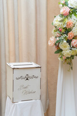 Decoration as a background for photos with the newlyweds. A white curtain, bouquets of roses, a teddy bear holding a heart with the words "I love you" and a gift box with best wishes written on it