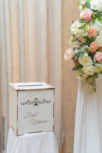 Decoration as a background for photos with the newlyweds. A white curtain, bouquets of roses, a teddy bear holding a heart with the words 